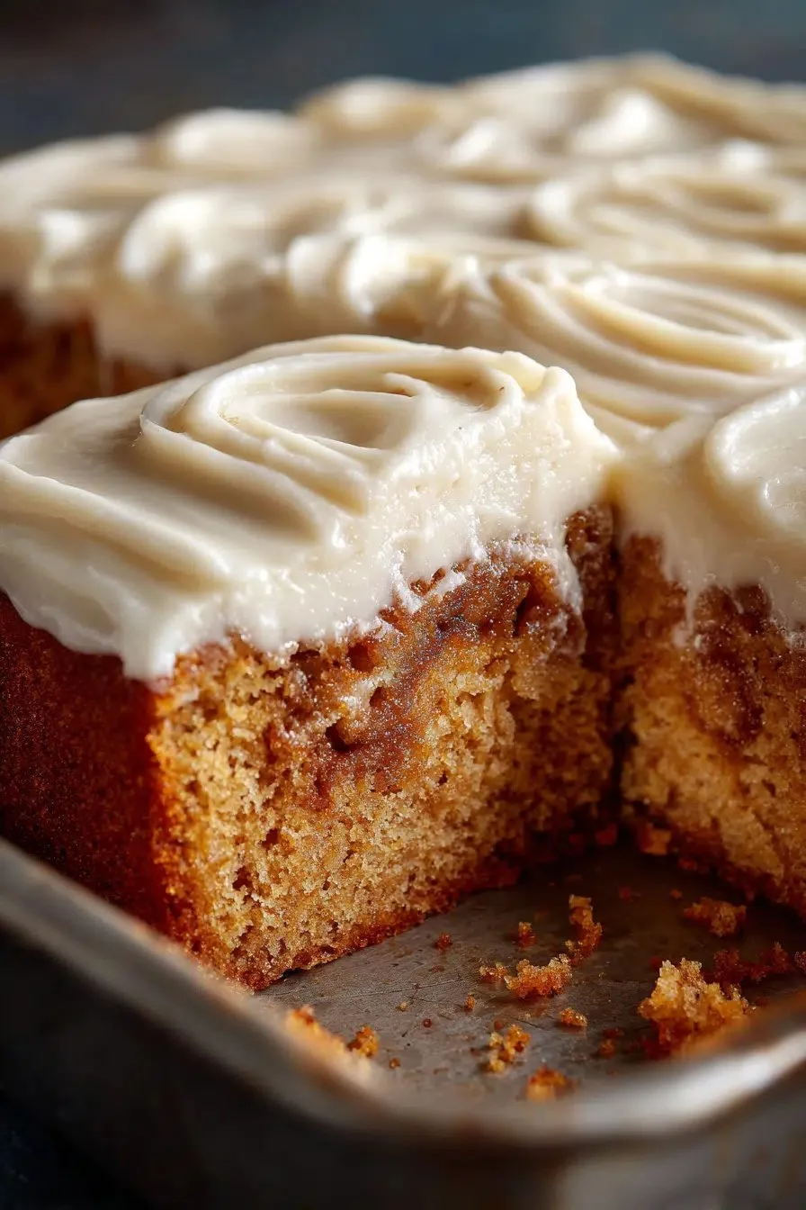Delicious cinnamon roll poke cake topped with creamy frosting and cinnamon swirls.