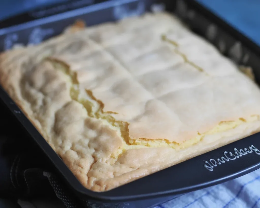 Deliciously moist French Butter Cake topped with a sweet glaze and served on a plate.