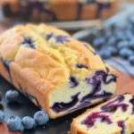 Blueberry Cream Cheese Bread with juicy blueberries and creamy filling on a rustic table.