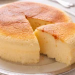 A slice of jiggly Japanese Cheesecake showcasing its fluffy texture and smooth top.