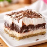 Chocolate Delight Dessert layered with cream cheese, chocolate pudding, and pecan crust.