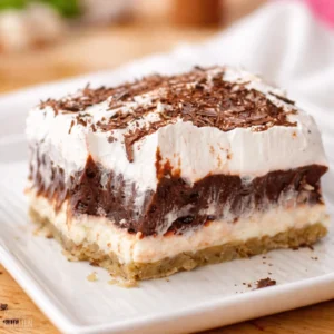 Chocolate Delight Dessert layered with cream cheese, chocolate pudding, and pecan crust.