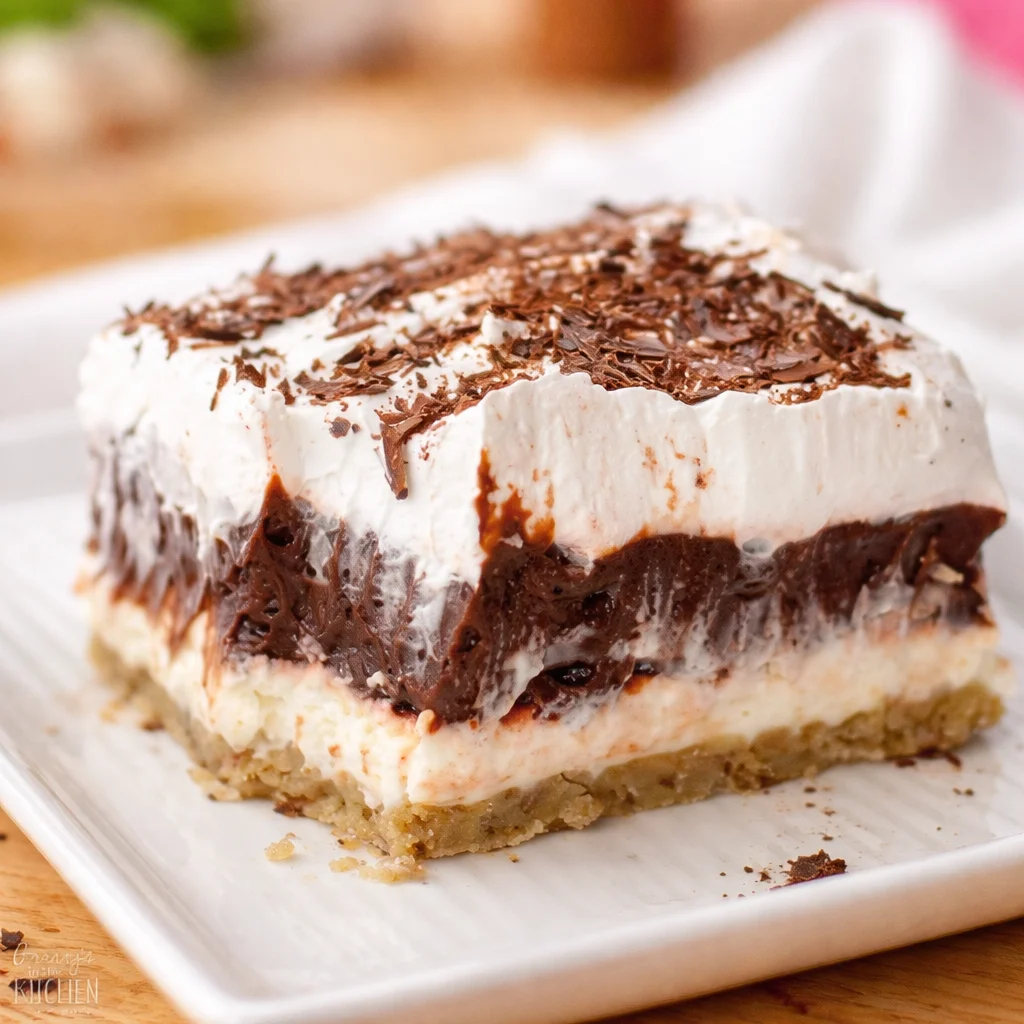 Chocolate Delight Dessert layered with cream cheese, chocolate pudding, and pecan crust.
