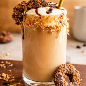 A refreshing Samoas Iced Coffee topped with chocolate and caramel drizzles