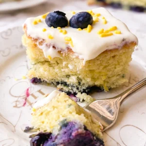 Moist Lemon Blueberry Sheet Cake topped with creamy frosting and fresh blueberries.