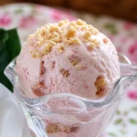 Delicious Divine Rhubarb Ice Cream served in a bowl with fresh rhubarb garnish.